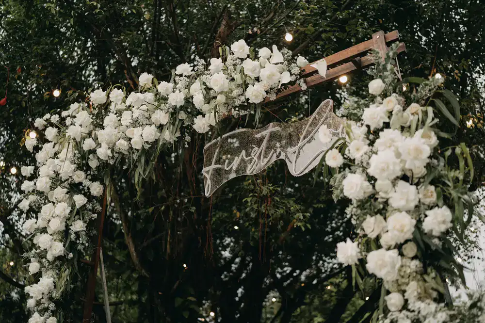 Large floral archway covered in roses and greenery
