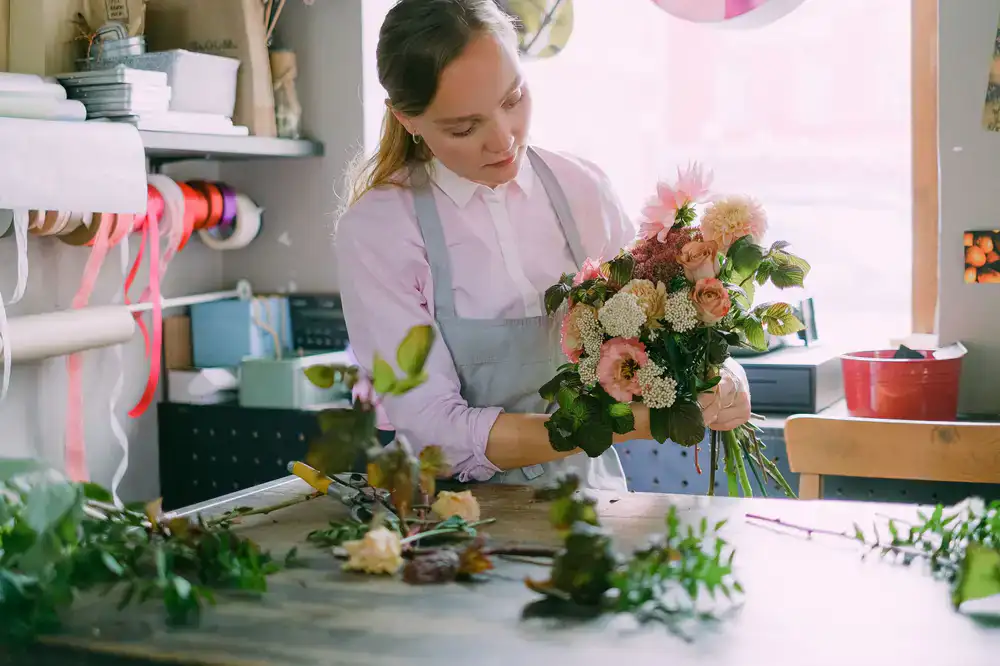 A florist carefully arranging stems in the studio